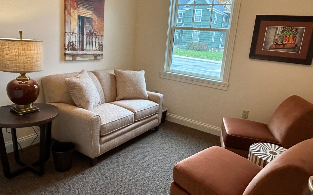 counseling room with cream couch and tan chairs