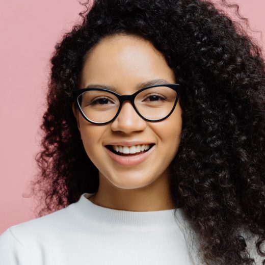 woman with black curly hair and glasses