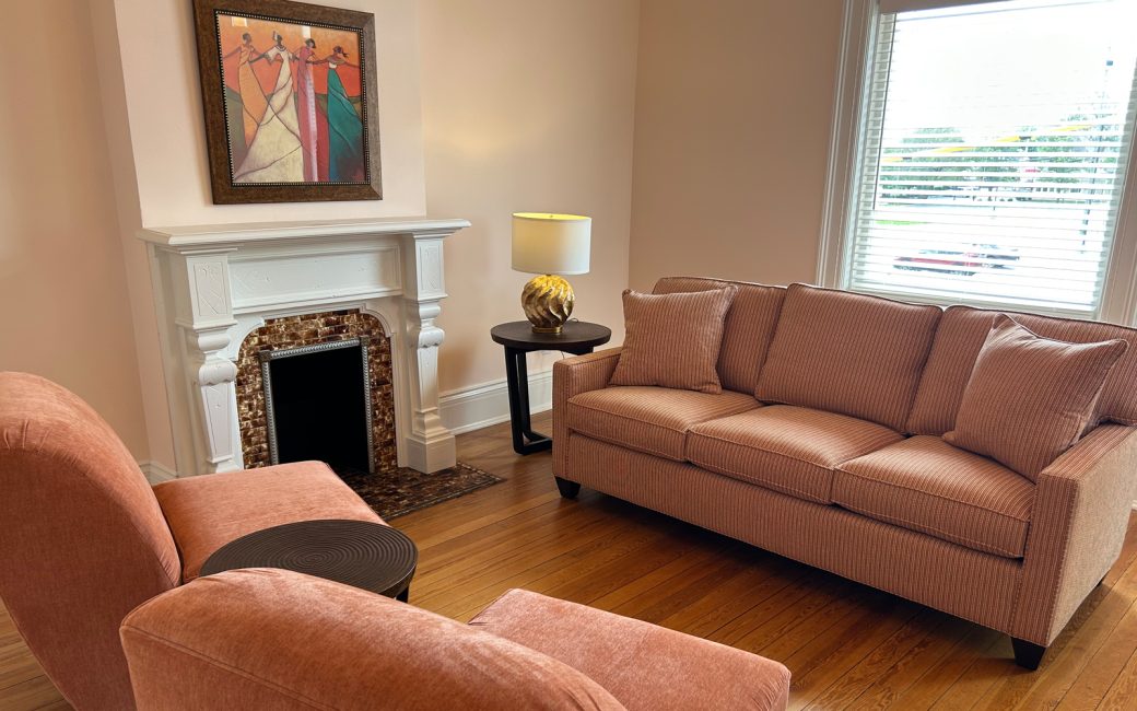 cozy waiting room with pink furniture and fireplace