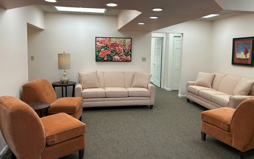 reception area with cream couches and orange chairs